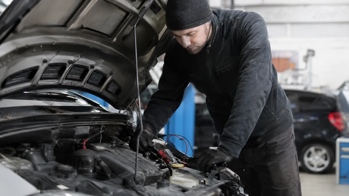 Technician reviewing winter battery and cooling system inspection checklist in service bay, 1200x675